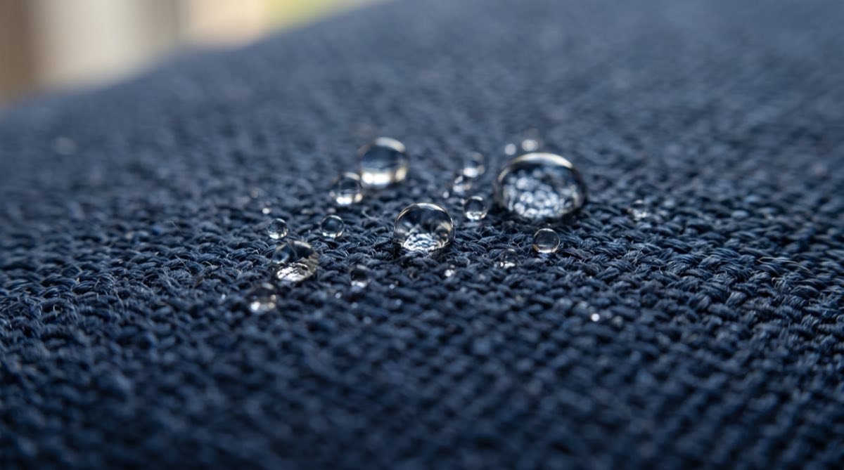 Gotas de água sobre tecido azul de sofá impermeabilizado, sem absorver